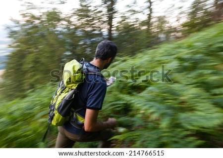 Hiker searching cache using global positioning device. Panning. Motion blur.