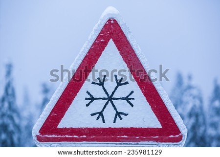 Traffic sign for icy road covered with ice