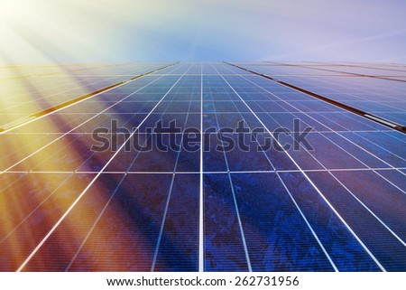 Solar panels and blue sky with sunlight shining on the panels