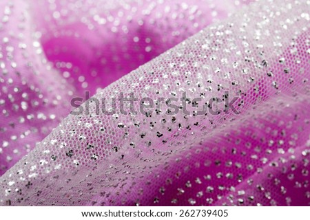 Fancy shiny glitter on a girly pink fabric, prepared for a dressing up, close-up