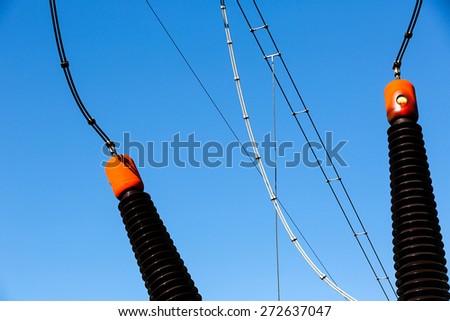 Ceramic insulators of a converter transformer in electrical substation (transformer station). Blue sky background, power, energy and electricity concept.