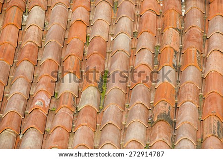 View of unique, weathered terracotta roof of a Mediterranean house. Textured effect background. Construction, home, protection and travel concept.