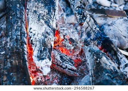 Embers of a self-made campfire, lit for cooking, roasting and water purification. Safety and survival, outdoor activity concept.