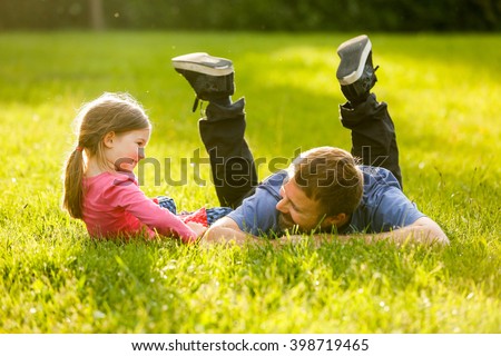 Devoted father and daughter enjoying eachothers company, bonding, talking, having fun in nature on a bright, sunny day. Parenthood, lifestyle, parenting, childhood and family life concept.