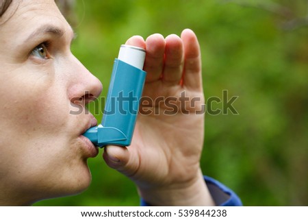 Asthma patient inhaling medication for treating shortness of breath and wheezing. Chronic disease control, allergy induced asthma remedy and chronic pulmonary disease concept.