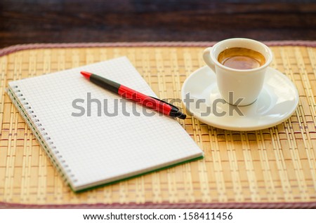 Coffee and note-book on the table