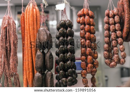 Smoked and homemade Spain sausages hanging at an outdoor market in Valencia, Spain/Sausages in market