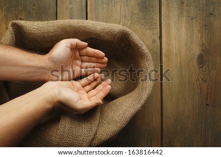 Cupped hands and sackcloth texture /Cupped hands and wood table with jute coarse grain canvas texture ( seamless sackcloth ).