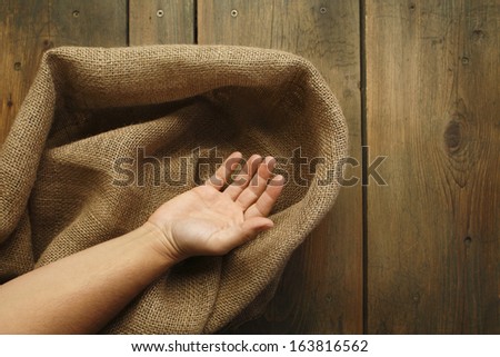 Wood and sackcloth texture/Human hand and wood table with jute coarse grain canvas texture ( seamless sackcloth ).
