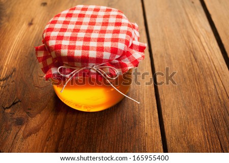 Honey jar on picnic table/Sweet food. Honey jar on picnic wooden table.