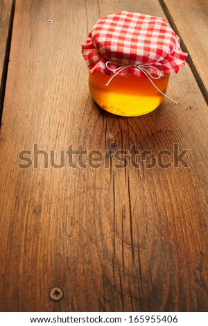 Honey jar on picnic table/Sweet food. Honey jar on picnic wooden table.