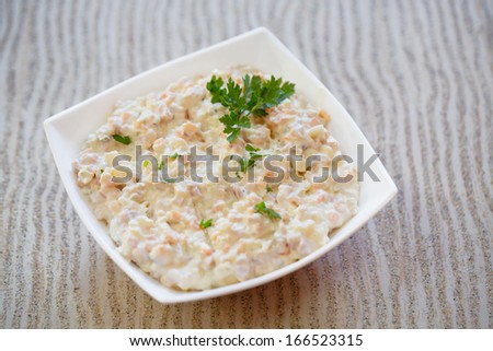 Salad/Olivier salad on table. Serving size of salad.Russian traditional salad olivier with pea