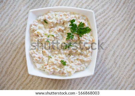 Salad/Olivier salad on table. Serving size of salad. Russian traditional salad Olivier with pea.
