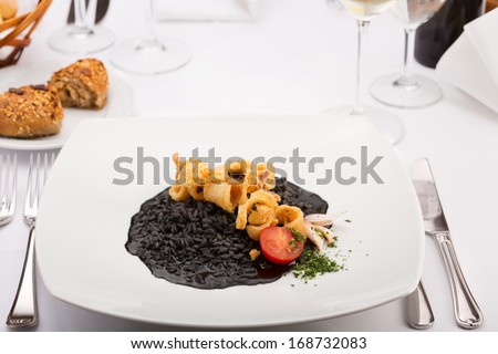 Black Risotto and Fried Calamari/Seafood. Delicious fried calamari ( Squid ) with Black Risotto. The color comes from the ink of squids (calamaris), Served with tomato, garlic and parsley,