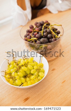 Grapes in a bowl on picnic table/Two bowls of grape over wooden background. Serving size of fresh fruit on picnic table