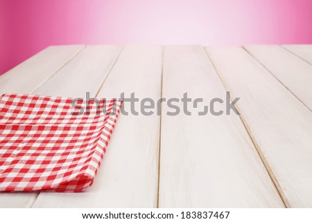 Plaid cloth on picnic table/Pink background.