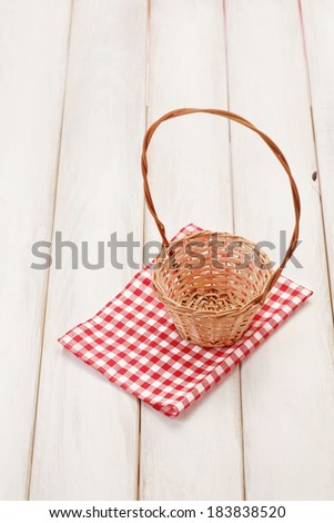 Basket on picnic table/Basket on wooden table. Red plaid cloth