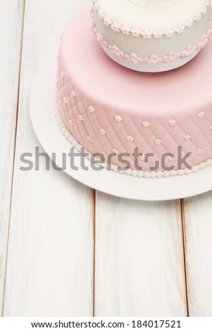 Cake/Decorative fondant pink cake on picnic table.