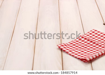 Wooden picnic table background with red plaid cloth/Plaid cloth on picnic table
