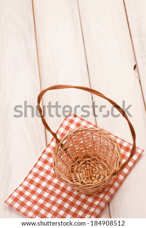Basket on picnic table/Basket on wooden table. Red plaid cloth