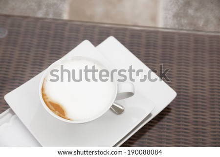 Cappuccino coffee serving in cafe/Decorative coffee set in cafe. Close up of coffee cup.