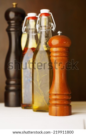 Bottles of olive, vinegar and spice arranged in restaurant. Shallow depth of field for soft background/Pepper and salt. Olive oil with spice