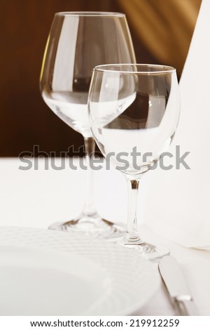 Fine dining restaurant.Fine dining restaurant. Dinner table place setting.Very shallow depth of field for soft background/Fine dining restaurant.Wine glasses.