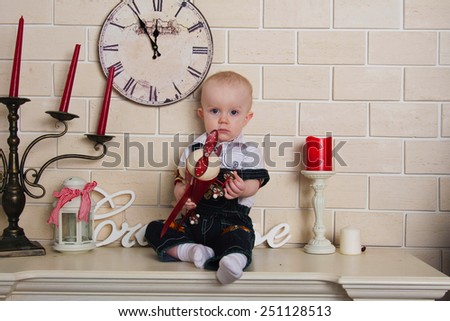 Photo baby boy sitting on the mantel with red plane in the hands of