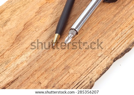 Pen and a screwdriver on the old wooden floor.