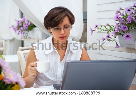 Young woman working on a computer in the restaurant