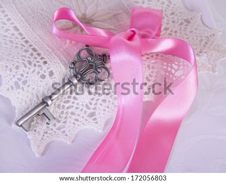 Photo classical key with a pink ribbon on lacy napkin