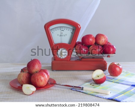 Still life with weights and red apples on white background