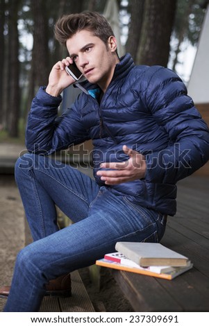 Handsome young man with a book and phone