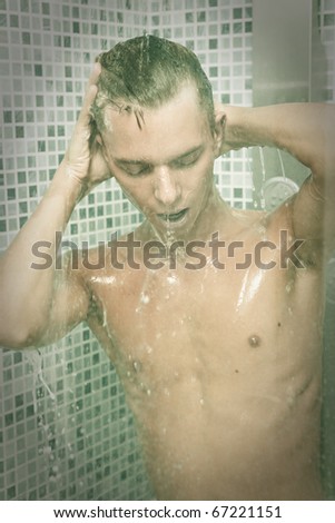 Man washing his hair as he takes a shower