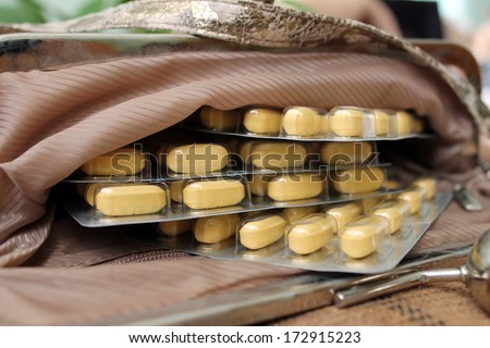 Contents female bags. Things from open bag. Yellow tablets, vitamins, dietary supplement.
