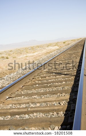 Railroad track in the Nevada desert with vanishing point and some blue sky for copy space.