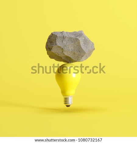Stone put on yellow light bulb floating on yellow background. minimal creative idea concept.
