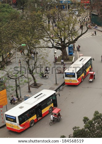 HANOI, VIETNAM - MAR 29, 2014: State owned bus parking on the side of street near Hoan Kiem lake. Hoan Kiem lake area is known as the center of Hanoi capital.