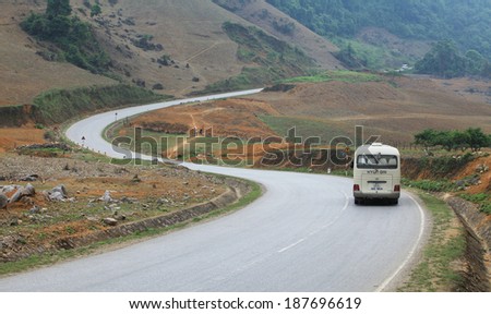 SON LA, VIETNAM - APR 10, 2014: A passenger car running on a S-shape road through Moc Chau highland toward the far north west of Vietnam. Moc Chau is known as a hometown of milk in the country.