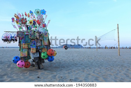 NGHE AN, VIETNAM - MAY 17, 2014: Unidentified motorbike fully loaded with made in China toys of a vendor parking on the beach of Cua Lo. Vendors are found everywhere in Vietnam.