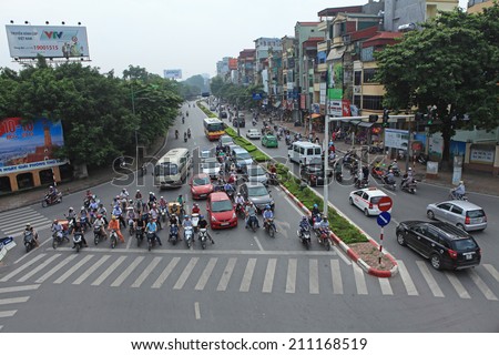 HANOI, VIETNAM - AUG 16, 2014: Vehicles stopping at the red light traffic on a crowded street in Hanoi capital. Traffic is one of the most serious problems in this developing country.