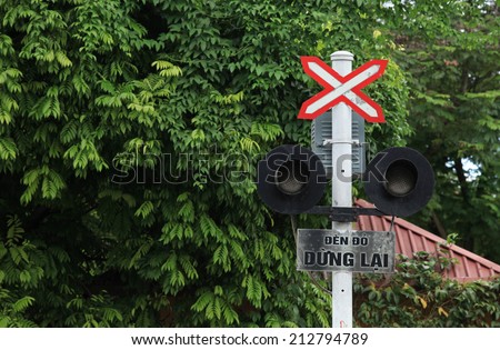 Stop sign at a cross with railway train. The words in sign mean \