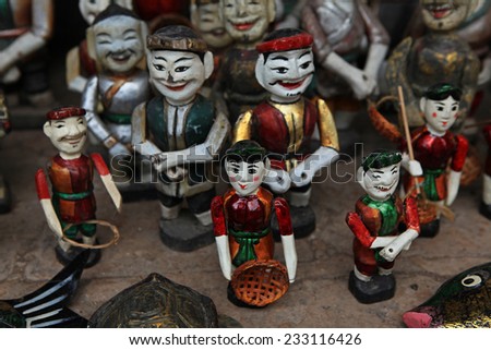 The traditional water puppets of the theater in Hanoi, Vietnam. Focus on the face of the puppet at the center of the photo.