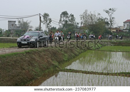 HANOI, VIETNAM - MAR 3, 2014: A wedding car carrying a just married couple on a country road to their new home. Getting married is one of the 3 greatest events for every Vietnamese.