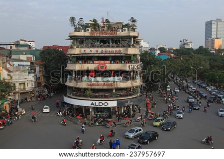 HANOI, VIETNAM - DEC 13, 2014: Vehicles running on a busy street near Hoan Kiem lake (Sword lake) in Hanoi capital, Vietnam. This area is the center of Hanoi.