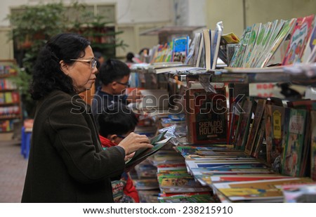 Hanoi, Vietnam - Dec 13, 2014: Unidentified Vietnamese woman buying books at Dinh Le street near Hoan Kiem lake in the center of Hanoi capital.