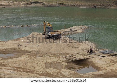 LAO CAI, VIETNAM - FEB 10, 2015: Machines digging into Chay river to mine sand, that resulting in many uncontrolled impacts of nature as types of climate change.