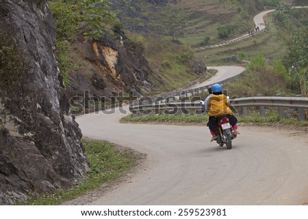 HA GIANG, VIETNAM - NOV 14, 2014: Unidentified Hmong minority people driving motorcycles on a mountain pass in Dong Van Karst Plateau Geopark, far north of Vietnam.