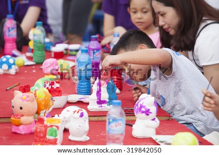 Hanoi, Vietnam - Sep 19, 2015: Asian children painting and writing their wishes on wishing cards in occasion of traditional Full Moon Festival (mid August of lunar calendar).