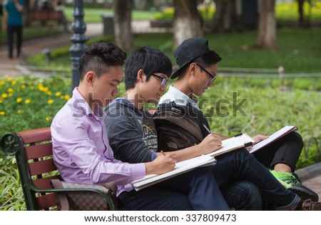 Hanoi, Vietnam - Nov 10, 2015: Asian fine art students practicing to draw at a green park on the bank of Hoan Kiem (Sword) lake in Hanoi capital, Vietnam.